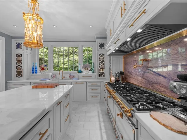 a kitchen with a stove a sink a window and cabinets