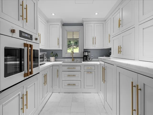 a kitchen with cabinets appliances a sink and a window