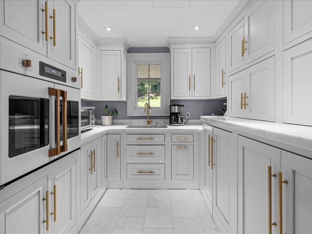 142 Crafts Road Brookline, MA 02467 - Photo 8 of 42 a kitchen with cabinets appliances a sink and a window