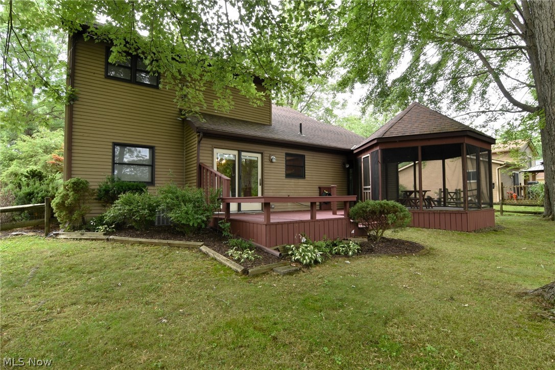 7655 Bellflower Road Mentor, OH 44060 - Photo 28 of 28 Rear view of house featuring a deck, a sunroom, and a lawn