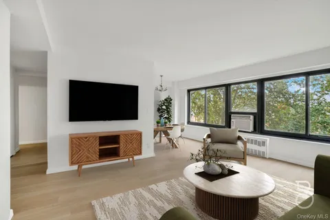 a living room with furniture a flat screen tv and a large window