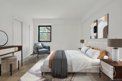 a bedroom with a bed a mirror and lamp