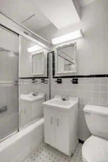 a bathroom with a sink toilet mirror and bathtub