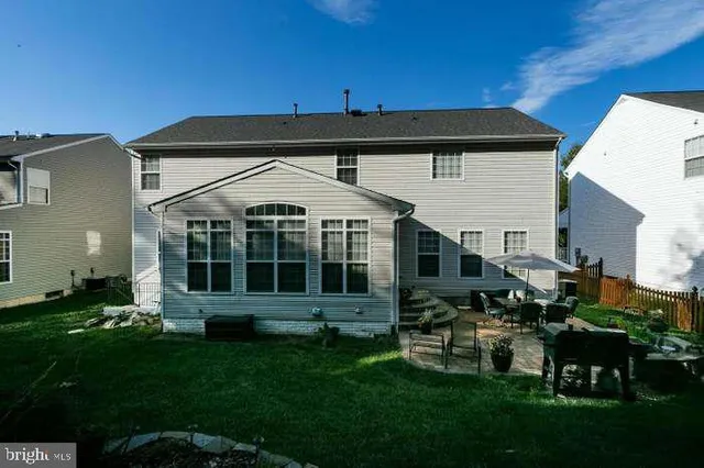 a view of a house with backyard and sitting area