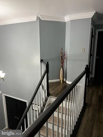 a view of staircase with wooden floor and fan
