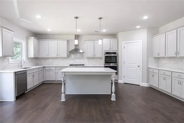 a kitchen with a refrigerator and white cabinets