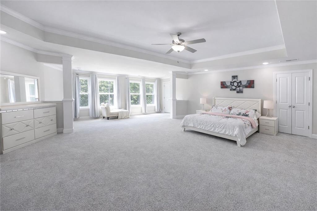 25 Hornbeam Way Covington, GA 30014 - Photo 15 of 31 a spacious bedroom with a large bed and a chandelier