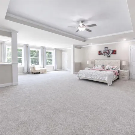 a spacious bedroom with a bed couch and a large window