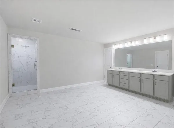 a bathroom with a double vanity sink mirror and shower