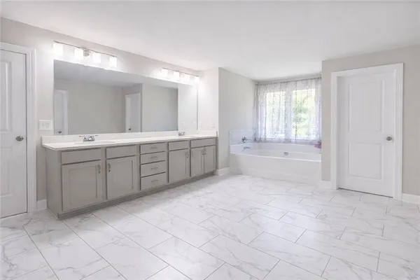 a spacious bathroom with a granite countertop sink a toilet and mirror