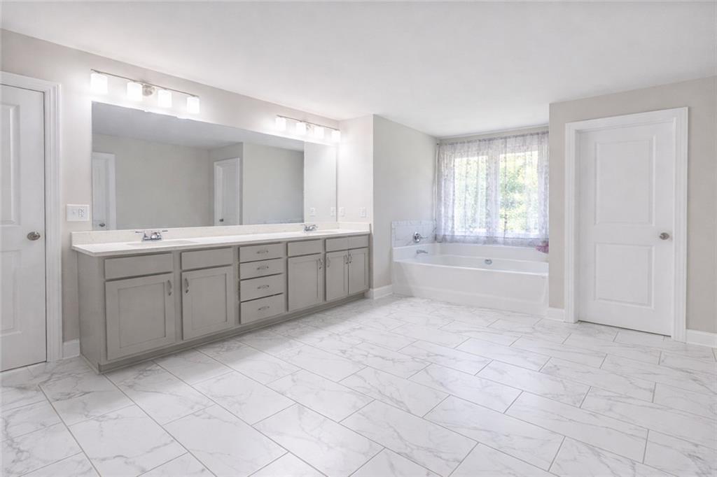 25 Hornbeam Way Covington, GA 30014 - Photo 19 of 31 a spacious bathroom with a granite countertop sink a toilet and mirror
