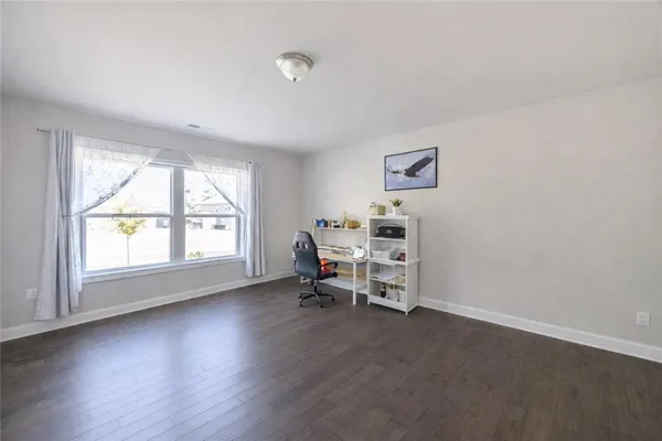 an empty room with windows and chair