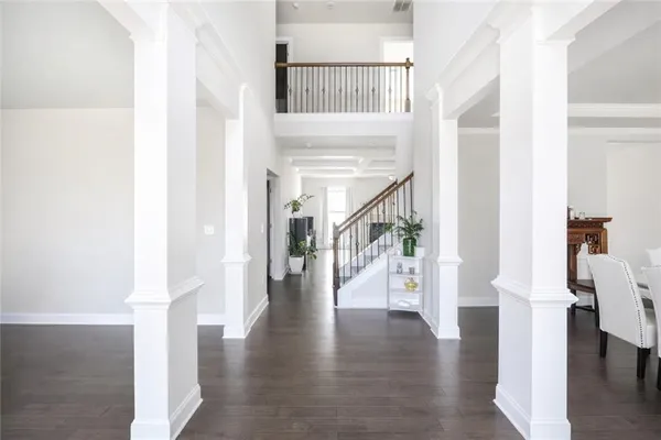 a hallway with wooden floor table and chairs