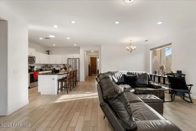 a spacious bedroom with a bed and a flat tv screen on the dresser