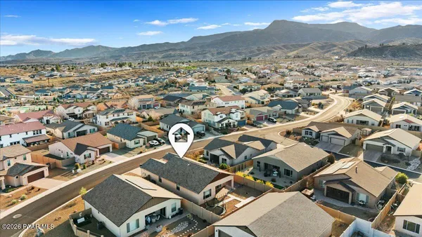 an aerial view of a house with a mountain