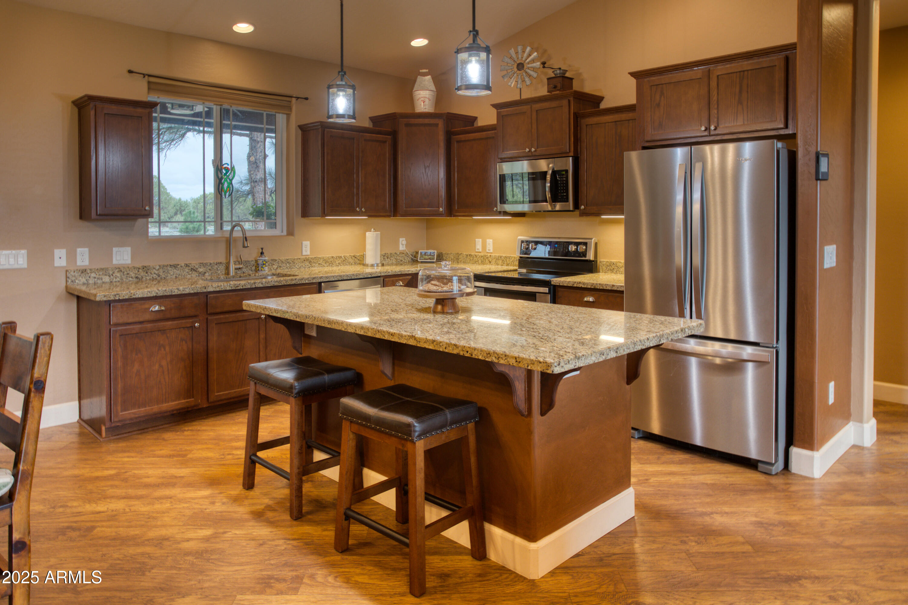 901 South Ridgeline Drive Show Low, AZ 85901 - Photo 8 of 31 a kitchen with stainless steel appliances granite countertop a table chairs sink refrigerator and microwave
