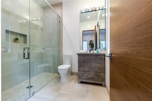 a bathroom with a shower a sink a toilet and a mirror