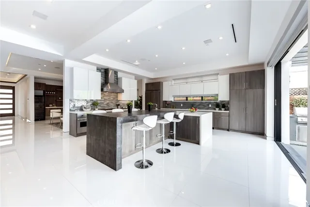 a kitchen with stainless steel appliances kitchen island granite countertop a refrigerator and a sink