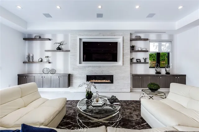 a living room with furniture a flat screen tv and a fireplace