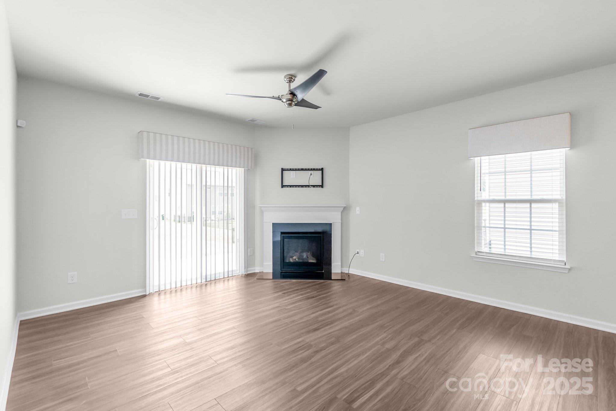15520 Capps Road Charlotte, NC 28278 - Photo 2 of 48 an empty room with wooden floor fireplace and windows