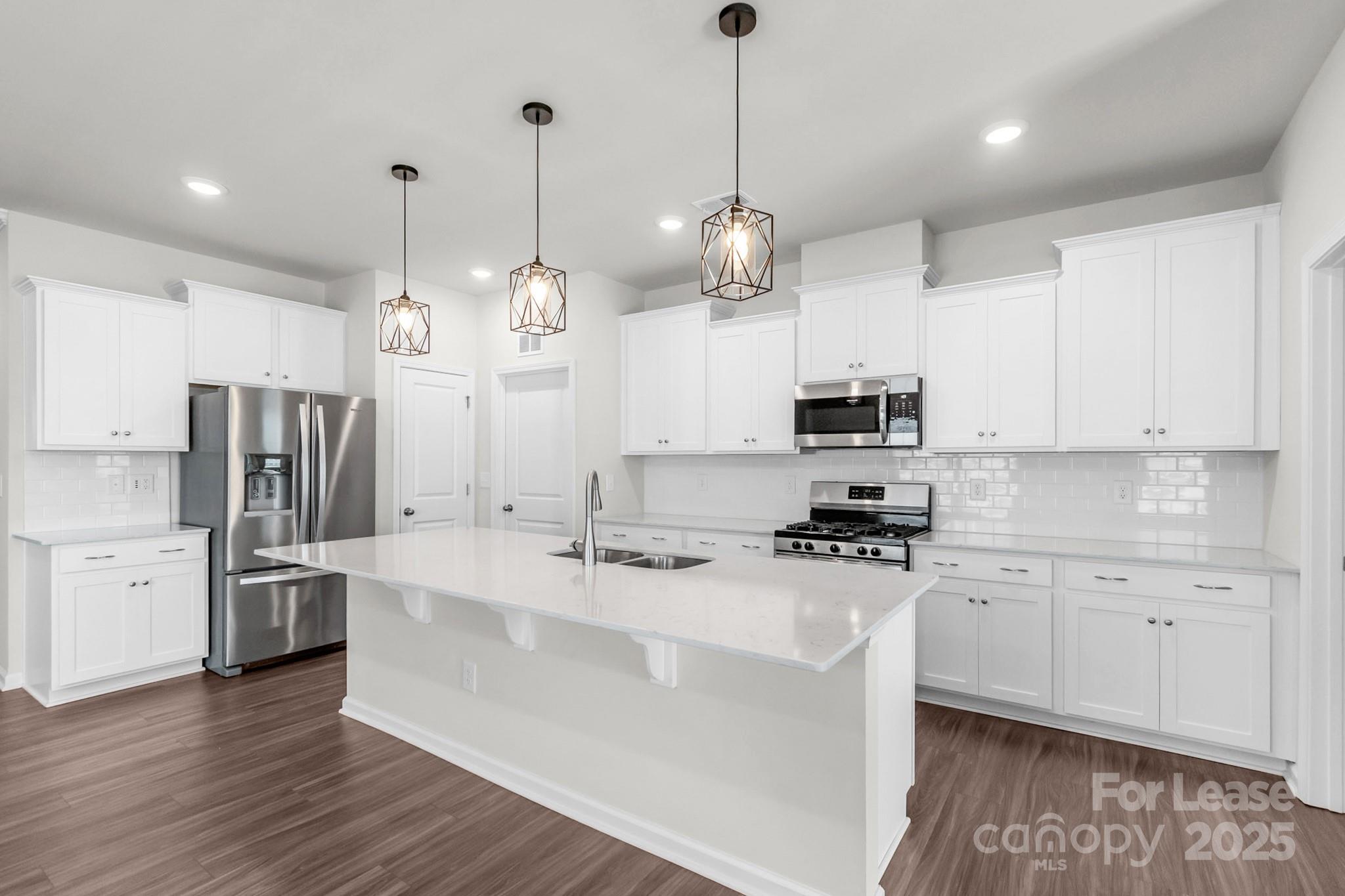 15520 Capps Road Charlotte, NC 28278 - Photo 3 of 48 a kitchen with stainless steel appliances kitchen island granite countertop a sink a stove a refrigerator and island with wooden floor