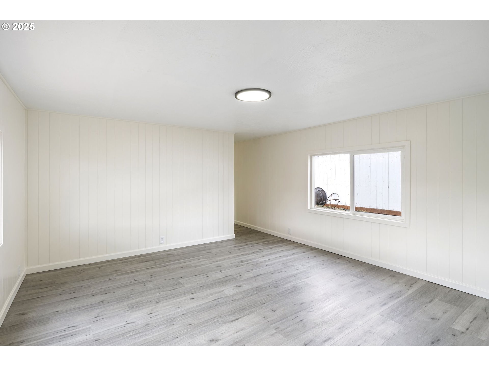 250 Northeast Jorgen Street Winston, OR 97496 - Photo 4 of 36 a view of an empty room with wooden floor and a window