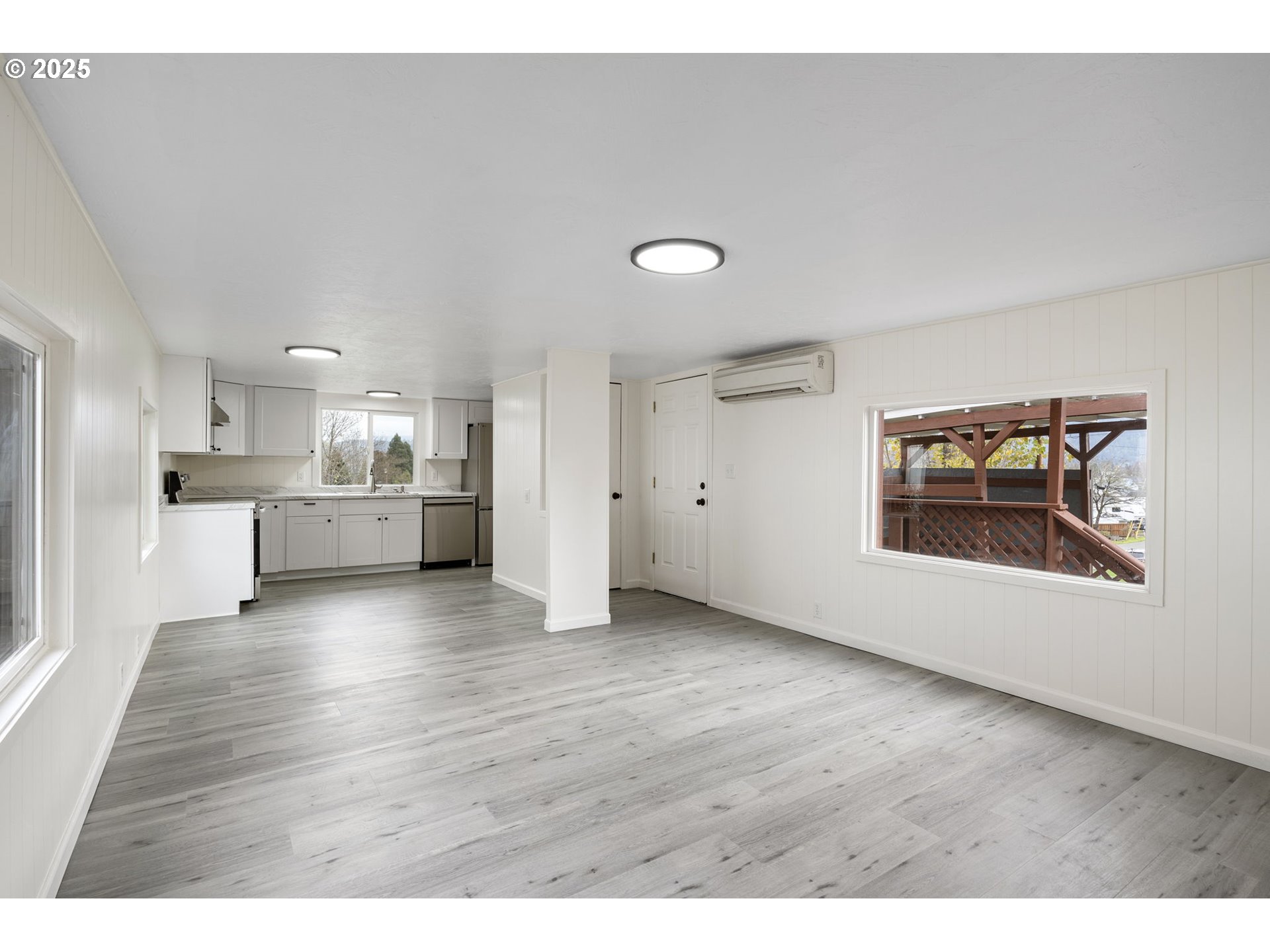 250 Northeast Jorgen Street Winston, OR 97496 - Photo 5 of 36 a view of a kitchen and an empty room with wooden floor