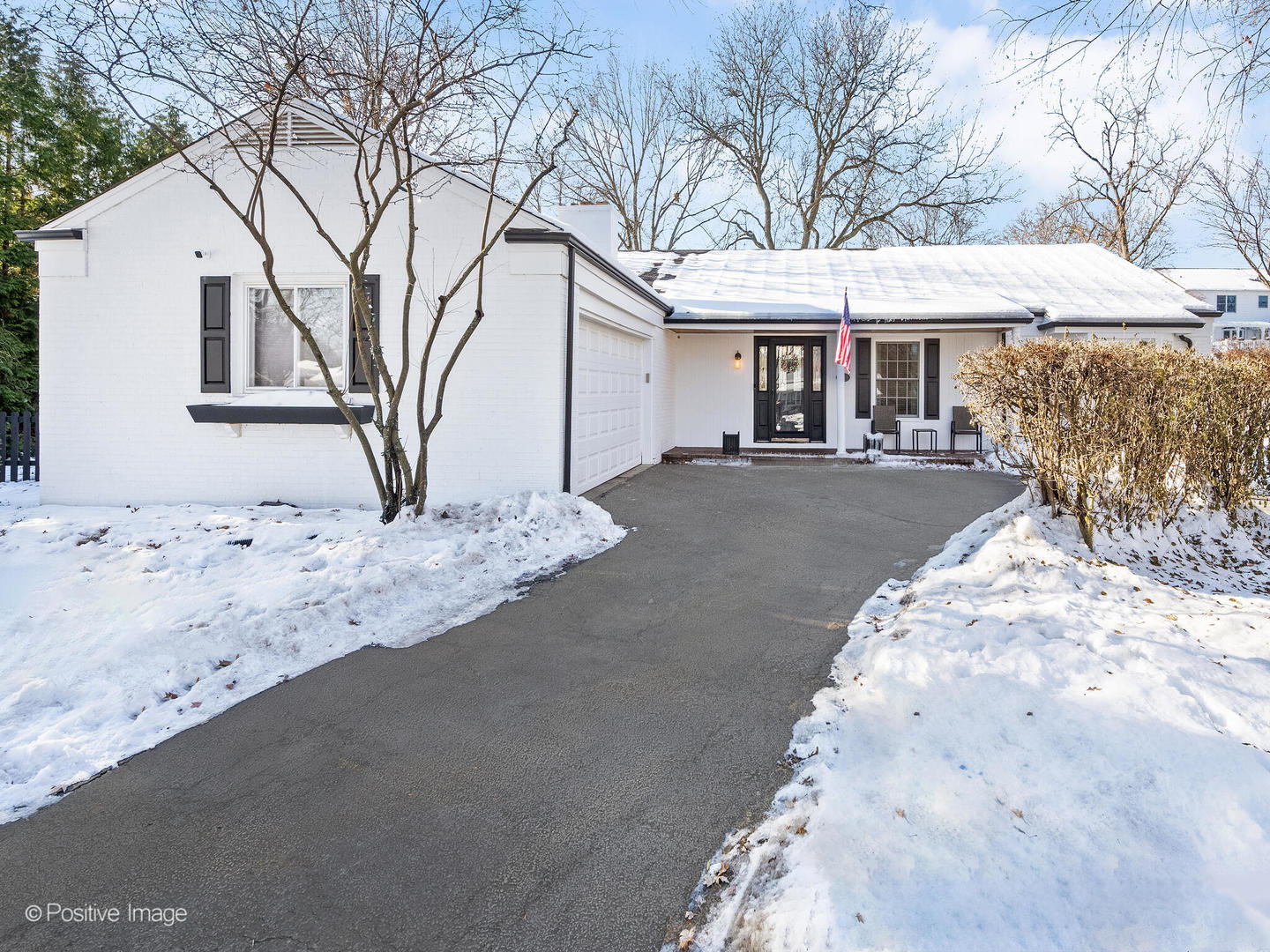 a front view of a house with a yard covered with snow in front of house
