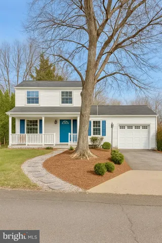 a front view of a house with a yard and potted plants