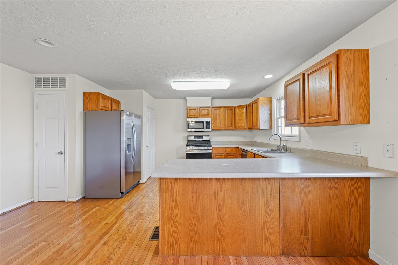 1418 Ogelthorpe Avenue Urbana, IL 61802 - Photo 12 of 36 a view of a kitchen with wooden floor and a sink