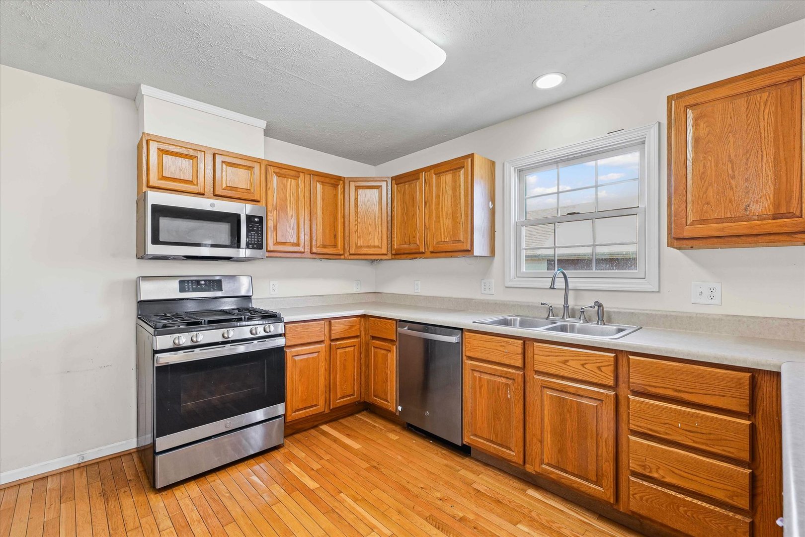 1418 Ogelthorpe Avenue Urbana, IL 61802 - Photo 13 of 36 a kitchen with stainless steel appliances granite countertop wooden cabinets granite counter tops and a window