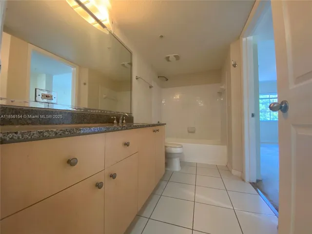 a spacious bathroom with a granite countertop sink and a mirror