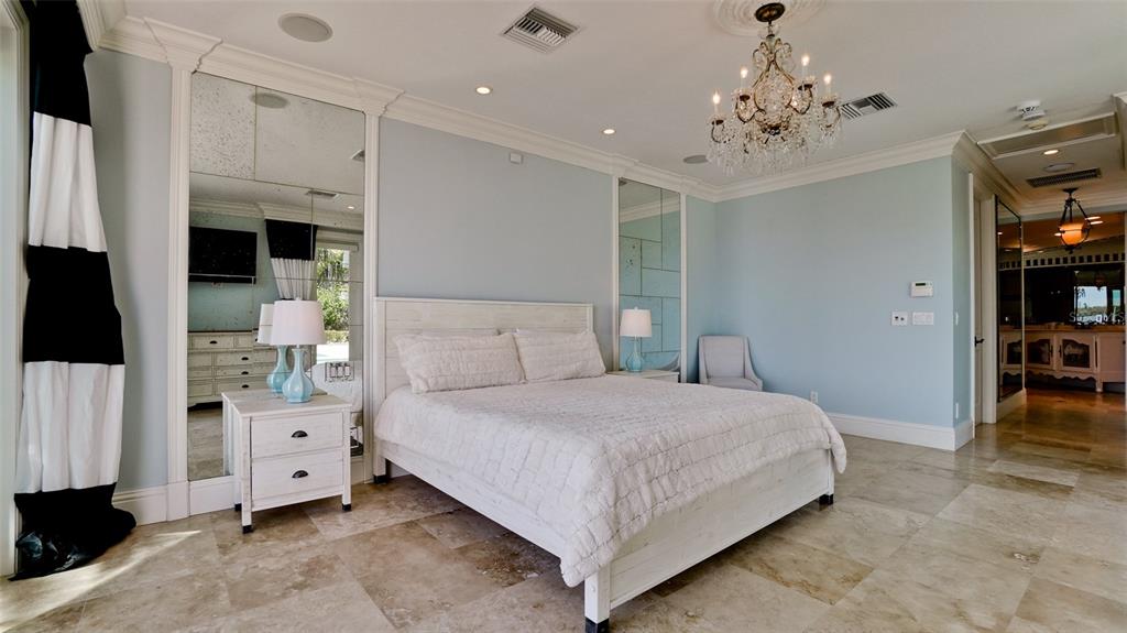 8213 Midnight Pass Road Sarasota, FL 34242 - Photo 20 of 52 a bedroom with a large bed and a chandelier