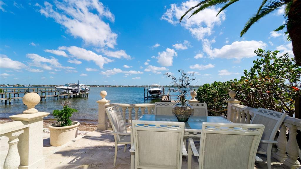 8213 Midnight Pass Road Sarasota, FL 34242 - Photo 22 of 52 a view of a patio with table and chairs and potted plants