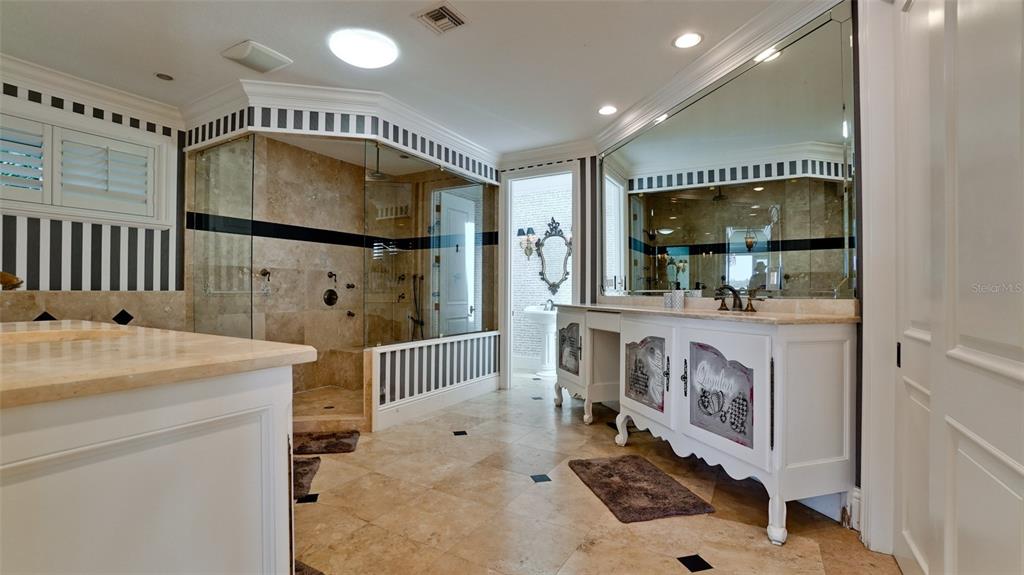 8213 Midnight Pass Road Sarasota, FL 34242 - Photo 24 of 52 a bathroom with a sink a mirror and shower
