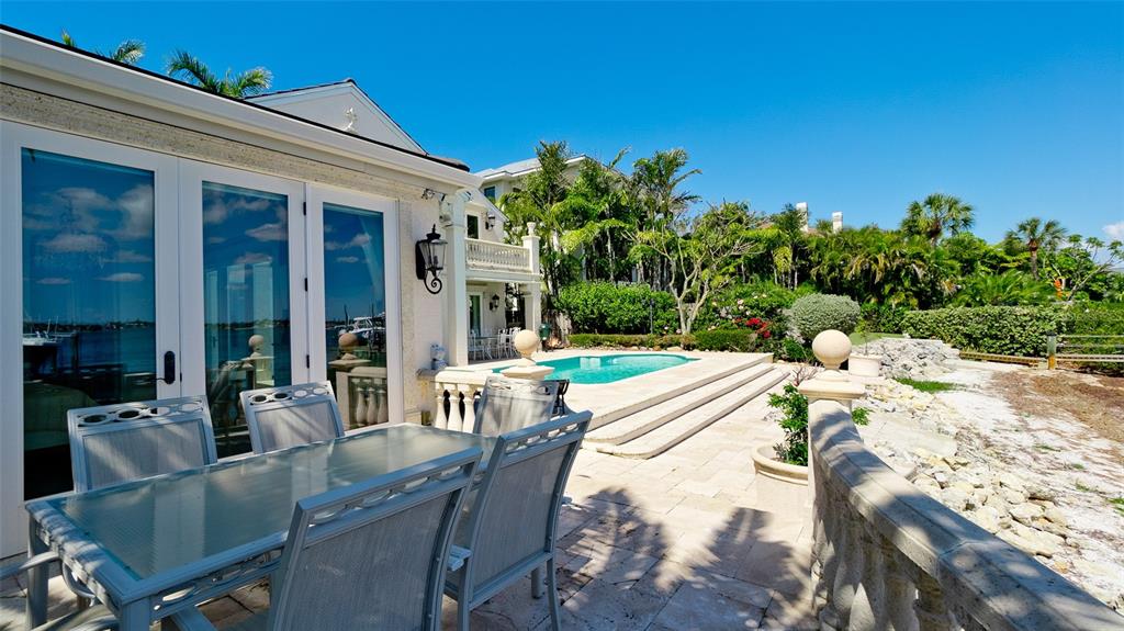 8213 Midnight Pass Road Sarasota, FL 34242 - Photo 46 of 52 a view of a patio with table and chairs and potted plants