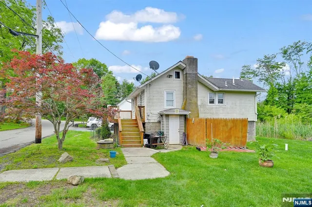 a view of a house with backyard and a tree