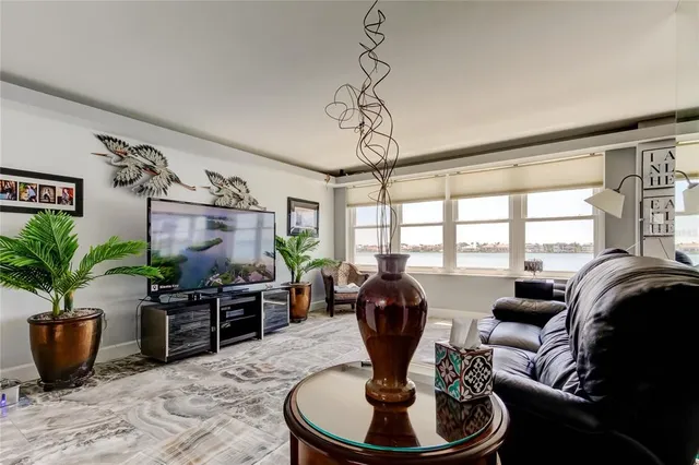 a view of a living room with furniture and floor to ceiling windows