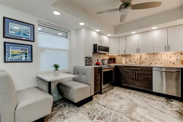 a kitchen with stainless steel appliances kitchen island granite countertop a sink and a refrigerator