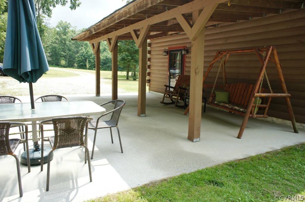 a view of a patio with a table chairs and a backyard
