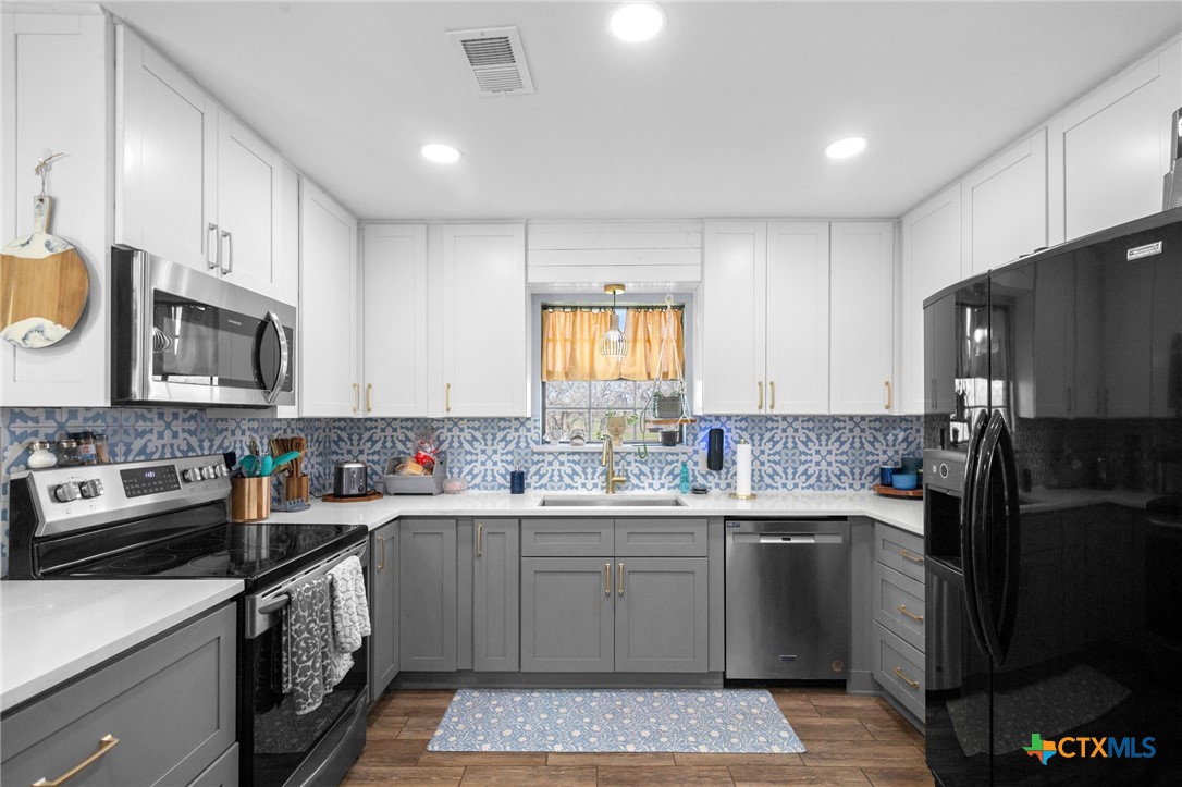 455 Suncrest Lane Victoria, TX 77905 - Photo 28 of 39 a kitchen with a sink a stove a refrigerator and cabinets