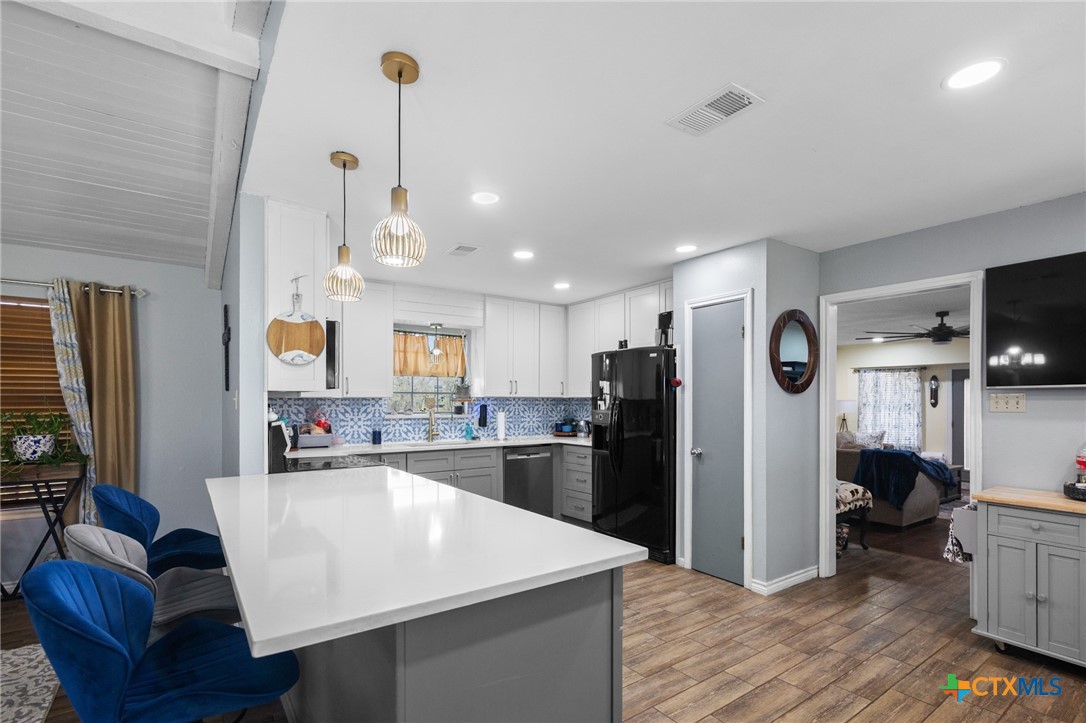 455 Suncrest Lane Victoria, TX 77905 - Photo 30 of 39 a kitchen with stainless steel appliances kitchen island granite countertop a refrigerator a stove top oven a sink and dishwasher