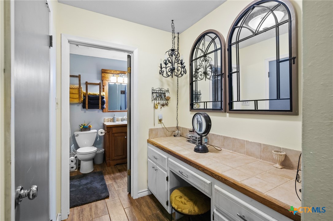 455 Suncrest Lane Victoria, TX 77905 - Photo 37 of 39 a bathroom with a granite countertop sink a toilet and a mirror
