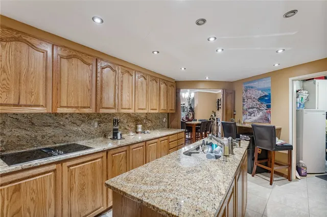 a large kitchen with kitchen island a sink table and chairs