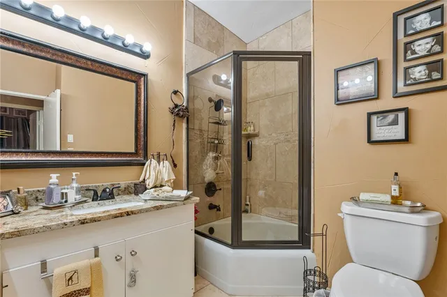 a bathroom with a granite countertop sink toilet and shower