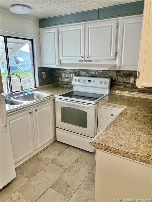 2692 Southwest Pontiac Place Stuart, FL 34997 - Photo 12 of 20 a kitchen with granite countertop a sink stainless steel appliances and cabinets