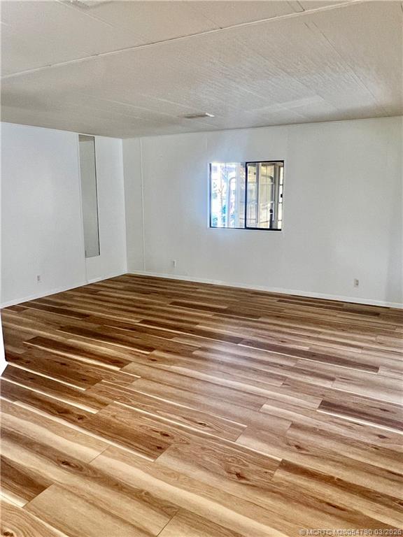 2692 Southwest Pontiac Place Stuart, FL 34997 - Photo 8 of 20 a view of a bedroom with wooden floor and window