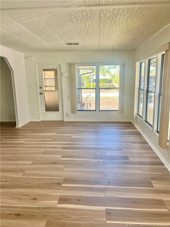 2692 Southwest Pontiac Place Stuart, FL 34997 - Photo 9 of 20 a view of an empty room with wooden floor and a window