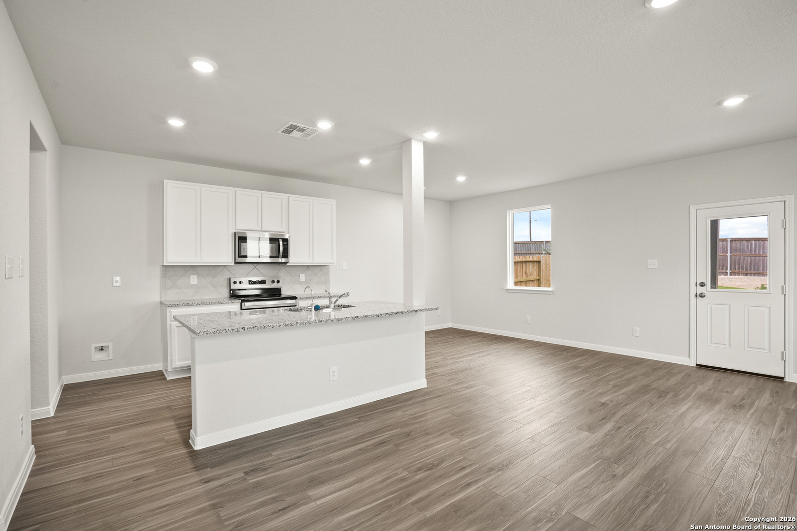 3215 Katzer Lane Converse, TX 78109 - Photo 2 of 23 a kitchen with stainless steel appliances wooden floors and white cabinets
