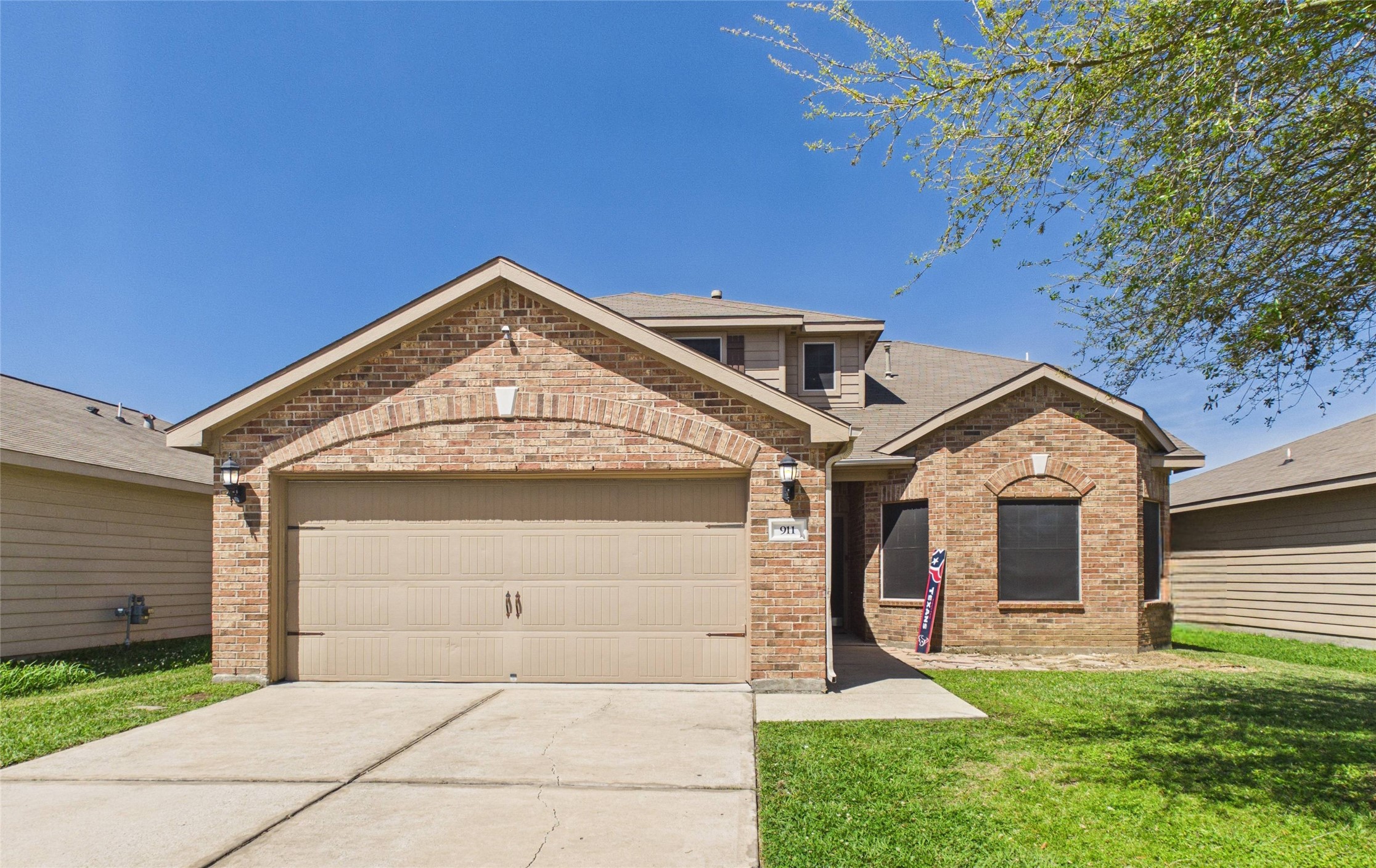 911 Marigold Road Baytown, TX 77521 - Photo 2 of 33 Charming brick home with a welcoming facade, featuring a spacious two-car garage and a neatly maintained front lawn.